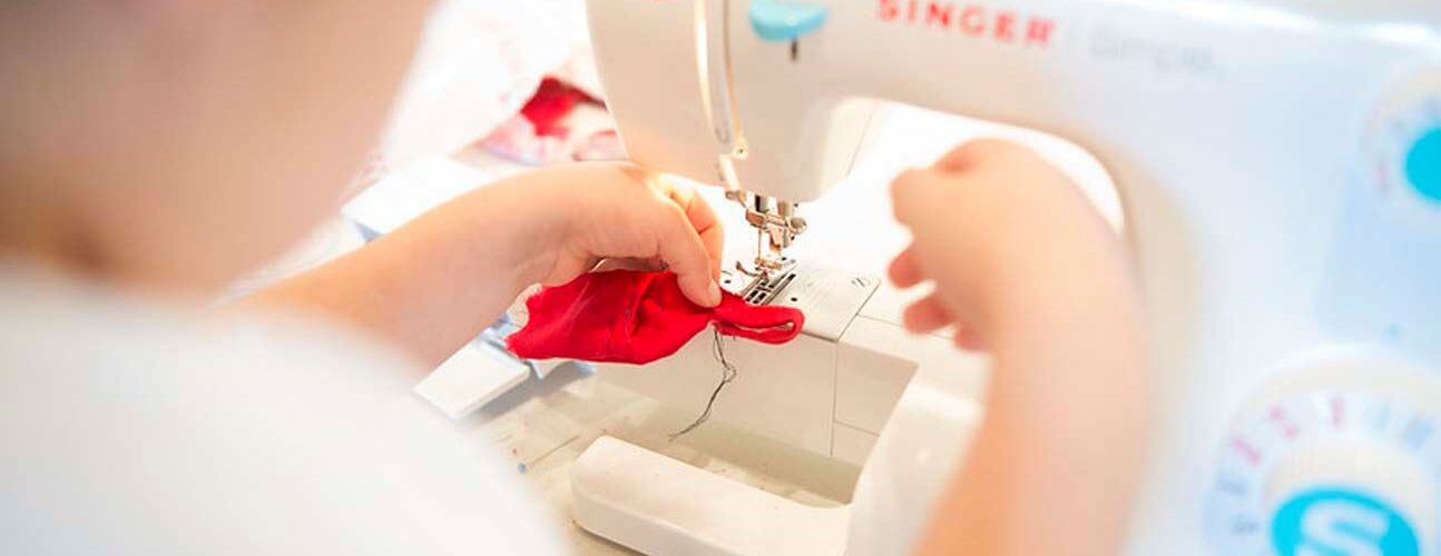 woman using singer sewing machine