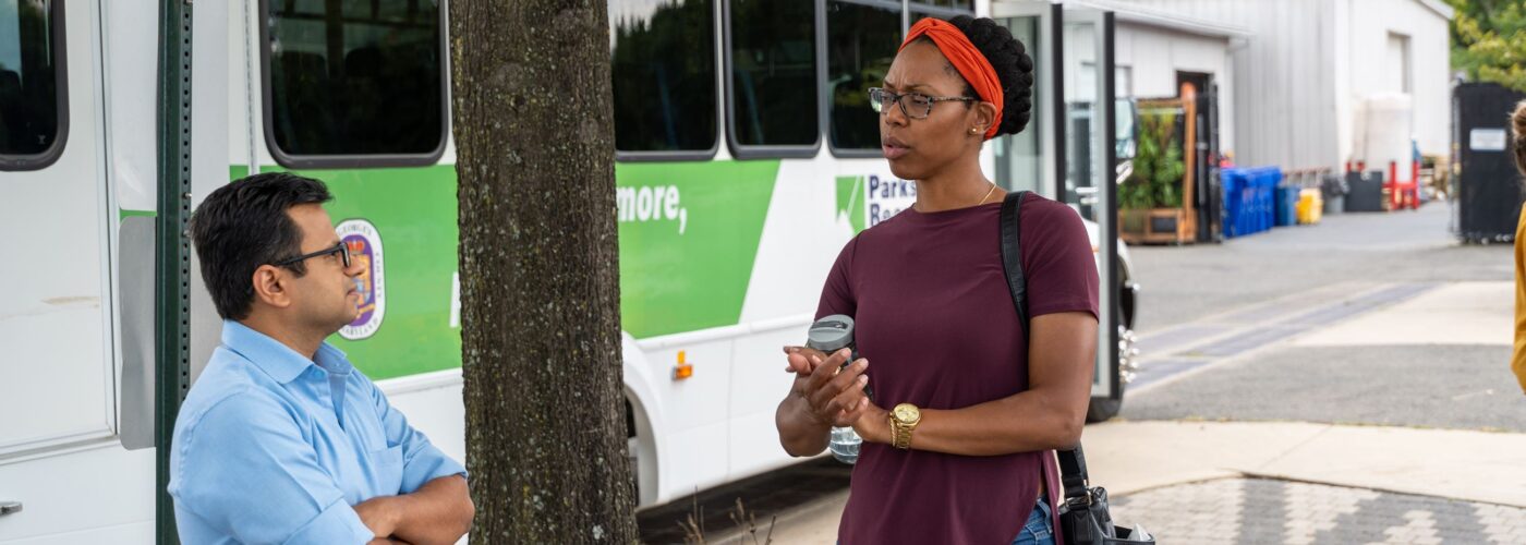 port town visit via Parks and Rec bus black woman discusses project with man