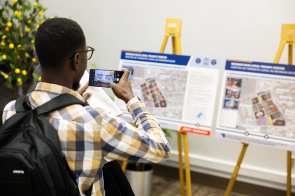 CABL open house- black teen takes a photo of project plans