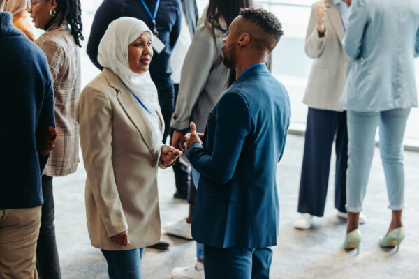 Diverse group of professionals networking and interacting at a business conference event. People are engaged in conversations and building connections, Photo by jacoblund, istockphoto.com