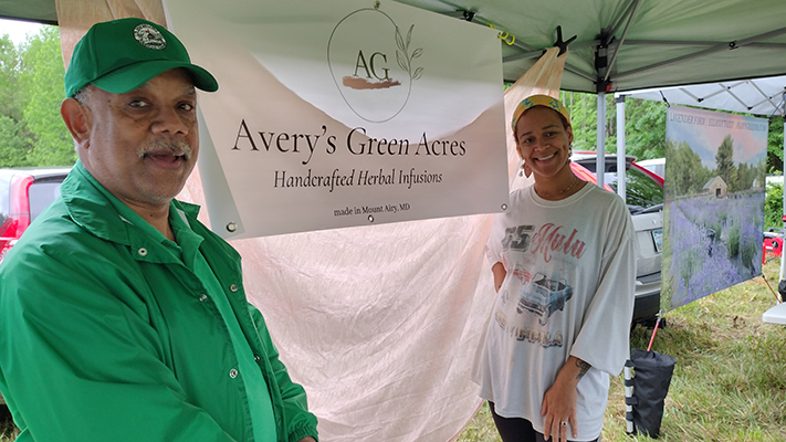 Avery Farms sign and hosts at a farmers market.