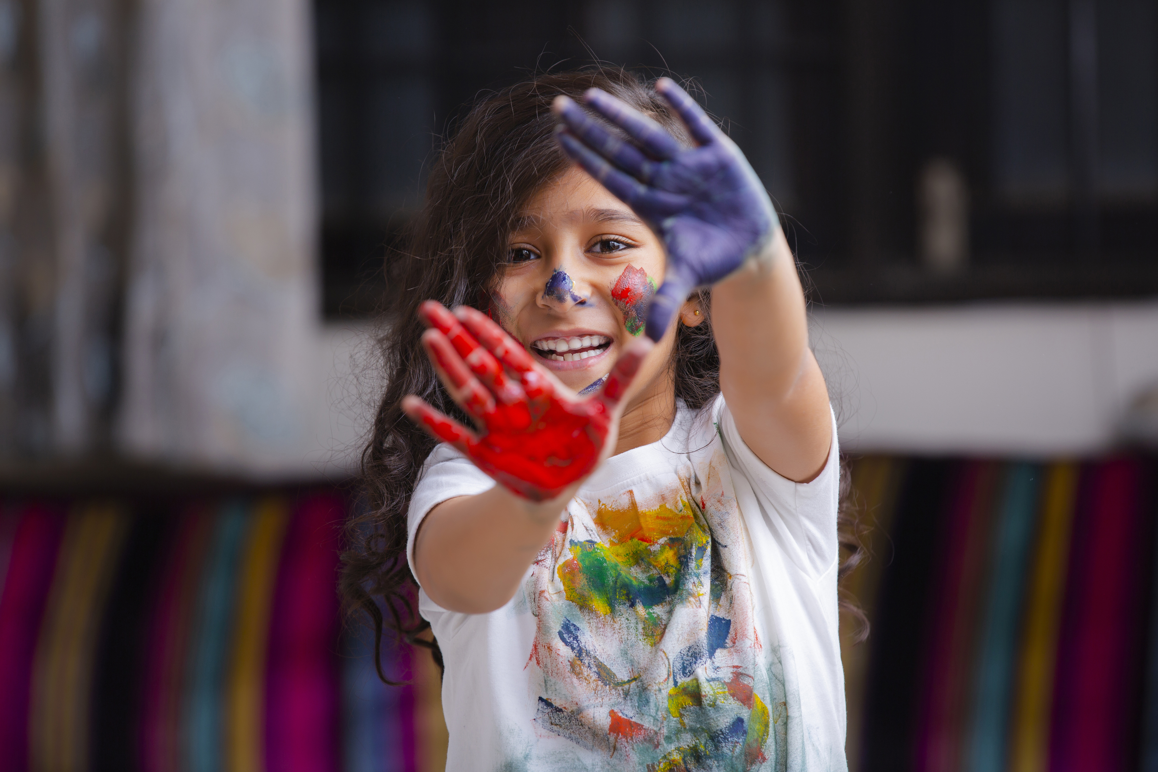 Girl with painted hands, framing camera.