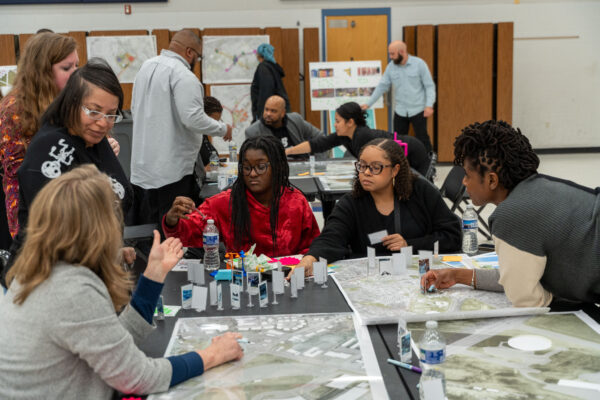 Community members review maps and design materials during a public planning workshop, collaborating on ideas for future neighborhood improvements