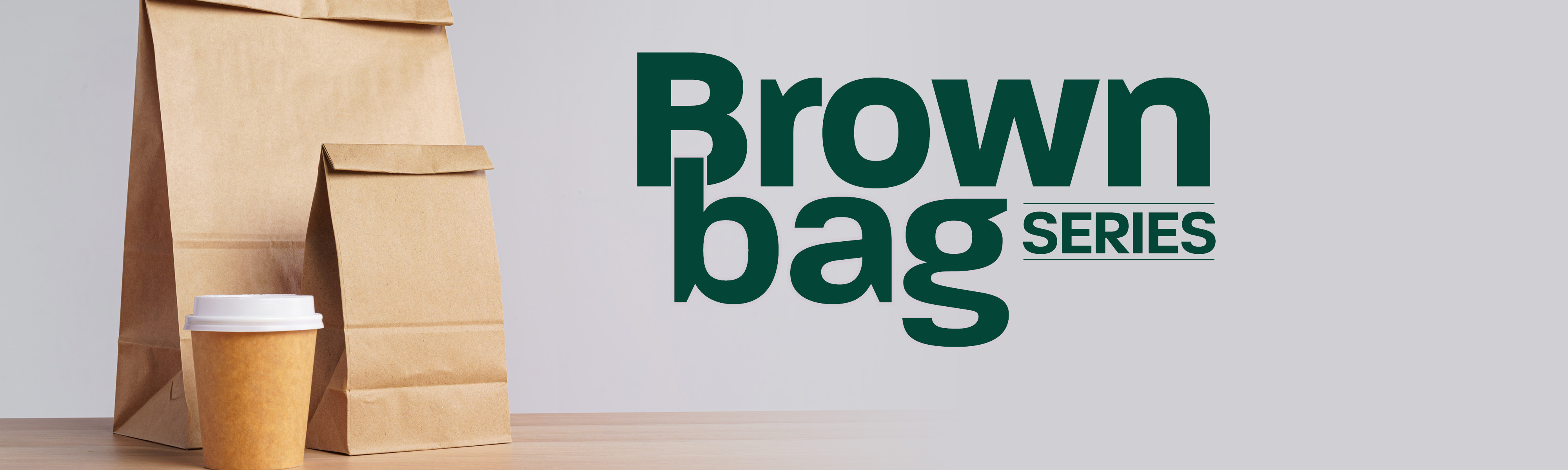 Text: Brown Bag Series, with two brown paper lunch bags and a brown paper coffee cup sitting on a wood table.