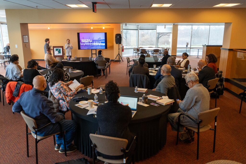 Stakeholders seated around tables listen to presenters at a Suitland cultural arts meeting.